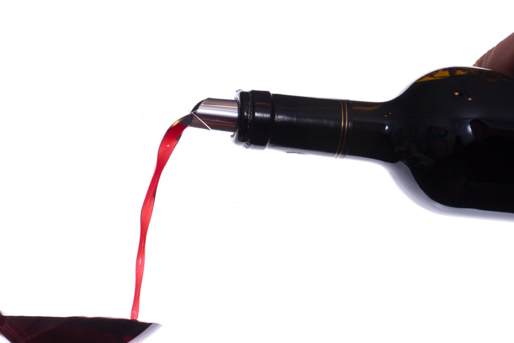 Rotwein in eine Glas einschenken