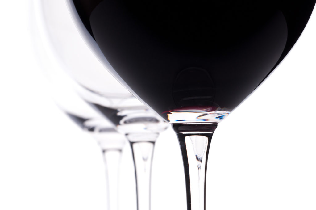 Drei Weingläser mit Rotwein im Gegenlicht